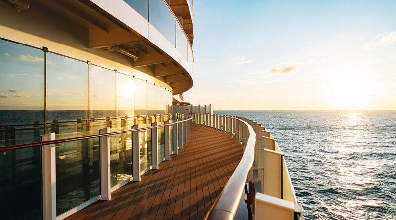 Sonnenuntergang über dem Meer, gesehen vom Außendeck eines Kreuzfahrtschiffs mit Glasgeländer.
