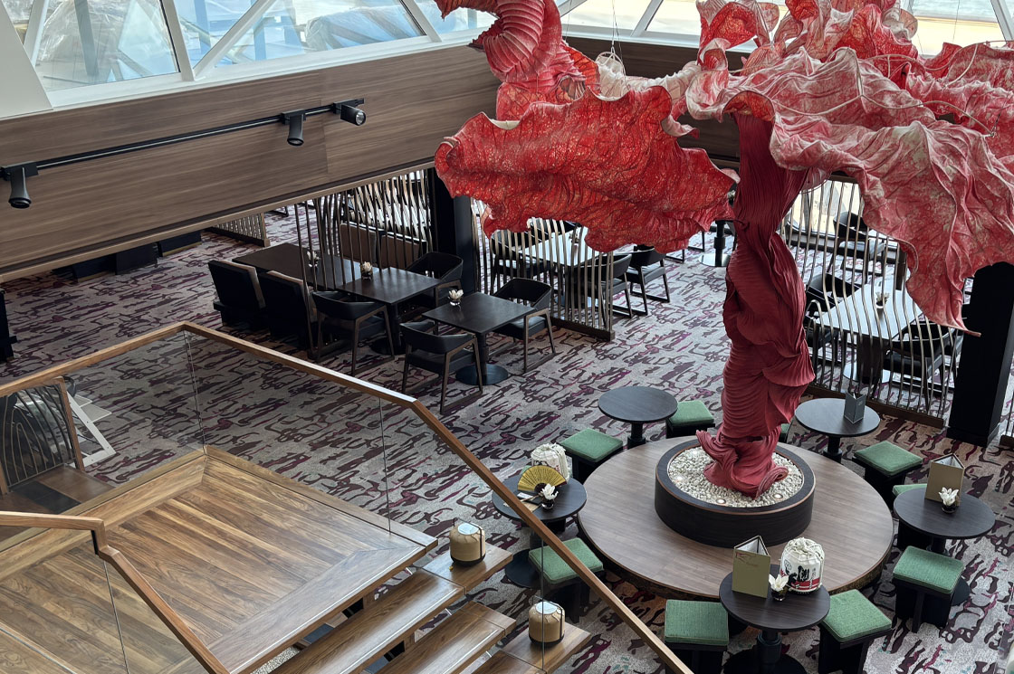 Neu gestalteter Hanami-Bereich auf der Mein Schiff 5 mit auffälliger roter Skulptur und stilvollen Sitzbereichen.